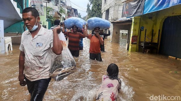 Sejumlah warga mengamankan barang-barang pribadi dari lokasi banjir di RT 03 RW 04 Cipinang Melayu pukul 13.00 WIB (Rahmat Fathan/detikcom).