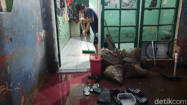 Warga di RW 04 Cipinang Melayu memberisihkan rumah usai banjir