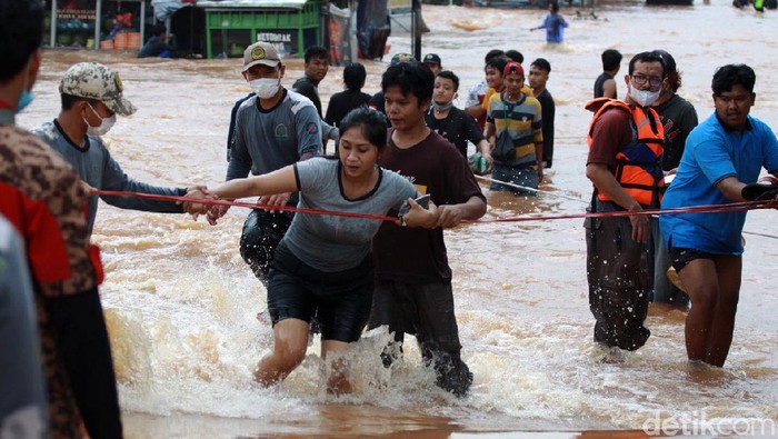 Banjir tak kunjung surut, warga Perumahan Bumi Nasio Indah, Bekasi, pun mulai dievakuasi. Proses evakuasi menggunakan tali tambang.