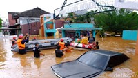 Perahu karet dikerahkan untuk mengevakuasi warga yang terjebak banjir di dalam rumahnya.