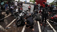 Bengkel itu tampak ramai oleh kendaraan bermotor yang mogok akibat menerobos banjir.
