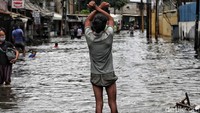 Warga membantu mengatur lalulintas yang macet akibat banjir.