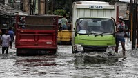 Mobil kecil tak berani melintas di jalan tersebut. Hanya kendaraan besar yang nekat menerobos banjir.