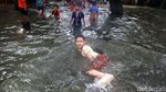 Keceriaan Anak-anak Bermain Banjir di Jalan Tendean