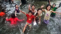 Sejumlah anak bermain di banjir di Jalan Kapten Tendean, Jakarta.