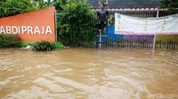 Meski berbahaya, mereka tetap bermain di genangan banjir.
