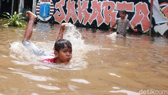 Banjir merendam salah satu RT di Ulujami, Jakarta Selatan, Sabtu (20/2/2021). Genangan banjir ini justru jadi arena bermain anak-anak.