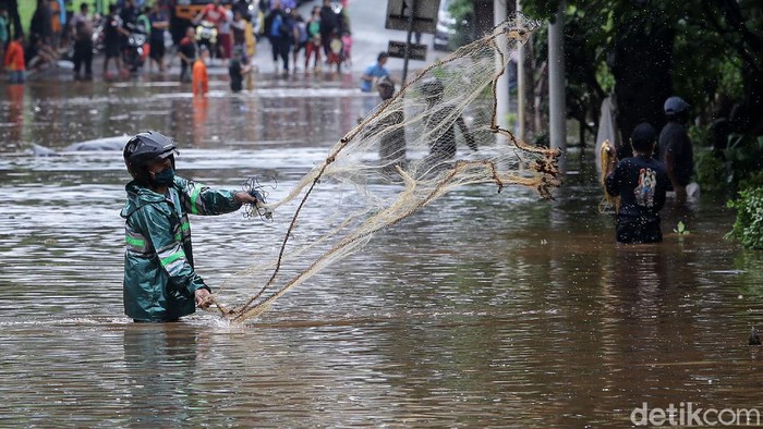 Menjala Ikan di Tengah Jalan TB Simatupang yang Kebanjiran Jalan TB Simatupang, Jakarta Selatan, terendam banjir, Sabtu (20/2/2021) pagi. Kondisi ini dimanfaatkan sebagian warga untuk menjala ikan.