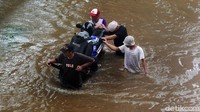 Ojek gerobak itu ditarik satu orang. Sementara dua orang lainnya mendorong dari bekalang.