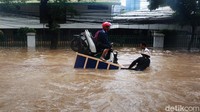 Ojek gerobak tampak wara-wiri mengangkut pemotor yang akan menyeberangi banjir.