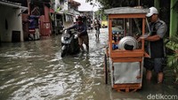 Pedagang kaki lima juga tetap mangkal meski jalanan terendam banjir.