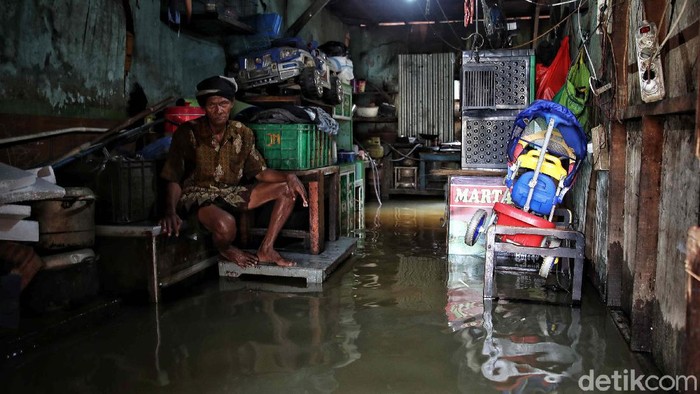 Sejumlah warga melintas di kawasan jalan Kapuk Muara, Penjaringan, Jakarta Utara, Sabtu (20/2). Banjir yang mulai datang sejak Subuh tadi mulai mengenangi pemukiman setinggi 30-70 cm.