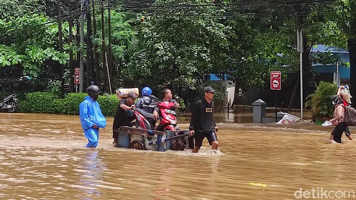 Pengendara motor banyak menggunakan jasa gerobak untuk melintasi Jalan Pejaten Barat Raya Jaksel yang banjir (Azhar BR/detikcom))