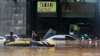 Perahu karet tampak wara-wiri untuk mengevakuasi warga yang terjebak banjir.