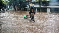 Pesepeda melintasi banjir setinggi lutut di Jalan Tendean.