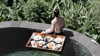 Liburan ke Bali tak lengkap tanpa menjajal floating breakfast. Menikmati ragam sarapan pun jadi lebih seru di kolam renang dengan latar pemandangan alam yang cantik. Foto: Instagram omardaniel_