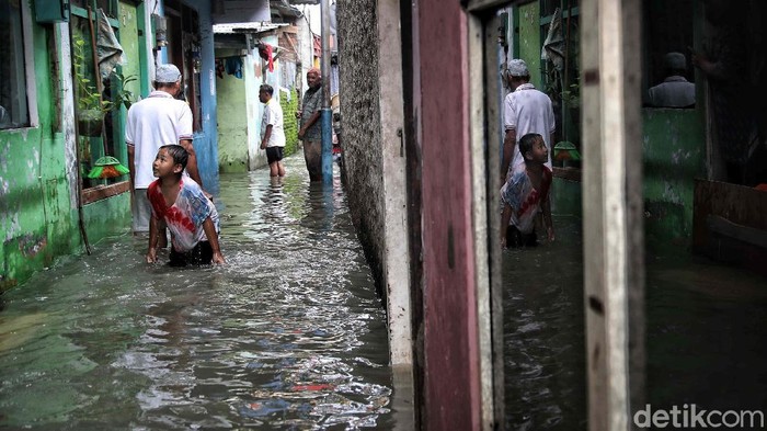 Tanggul Sungai Kapuk Muara Bocor Sejumlah warga beraktivitas di kawasan tanggul sungai di RT 7 RW 4,Kapuk Muara, Penjaringan, Jakarta Utara, Sabtu (20/2). Banjir yang mengenangi kawasan pemukiman tersebut diakibatkan karena intensitas hujan yang tinggi sejak semalam dan tanggul yang bocor karena tidak terawat sehingga tidak mampu menahan laju luapan sungai Kapuk Muara dan menyebabkan banjir