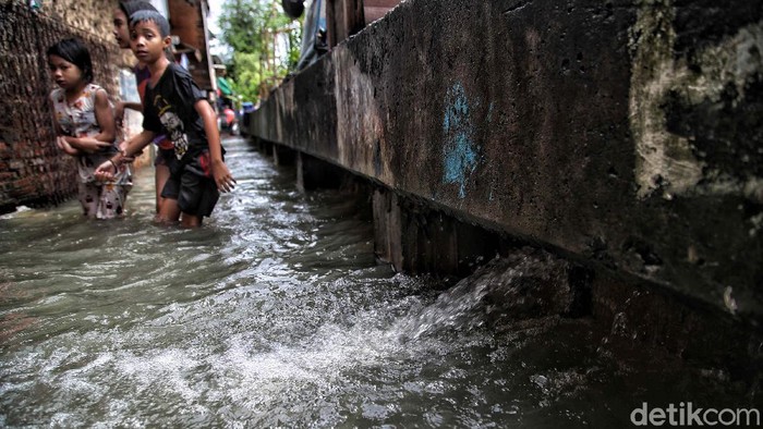 Tanggul Sungai Kapuk Muara Bocor Sejumlah warga beraktivitas di kawasan tanggul sungai di RT 7 RW 4,Kapuk Muara, Penjaringan, Jakarta Utara, Sabtu (20/2). Banjir yang mengenangi kawasan pemukiman tersebut diakibatkan karena intensitas hujan yang tinggi sejak semalam dan tanggul yang bocor karena tidak terawat sehingga tidak mampu menahan laju luapan sungai Kapuk Muara dan menyebabkan banjir