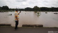 Seorang warga mengabadikan banjir yang merendam TPU Tanah Kusir.