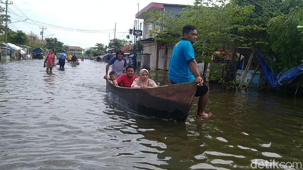 Banjir di Kota Pekalongan, Jawa Tengah, hingga saat ini belum surut, Minggu (21/2/2021). Perahu nelayan mondar-mandir di jalanan sebagai alat transportasi andalan warga terdampak.