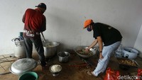 Para relawan tengah memasak di dapur umum untuk para korban banjir.