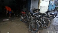 Warga tampak sibuk membersihkan lumpur sisa banjir.