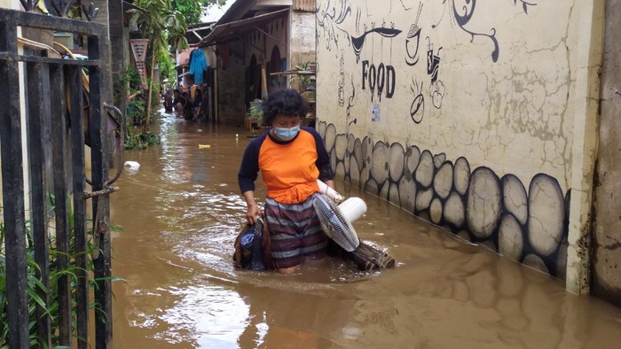 Warga Cipinang Melayu menyelamatkan barang berharga, Minggu (21/2/2021).