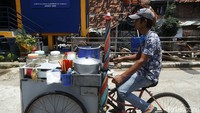 Warga melintas di depan rumah pompa Kampung Pulo.