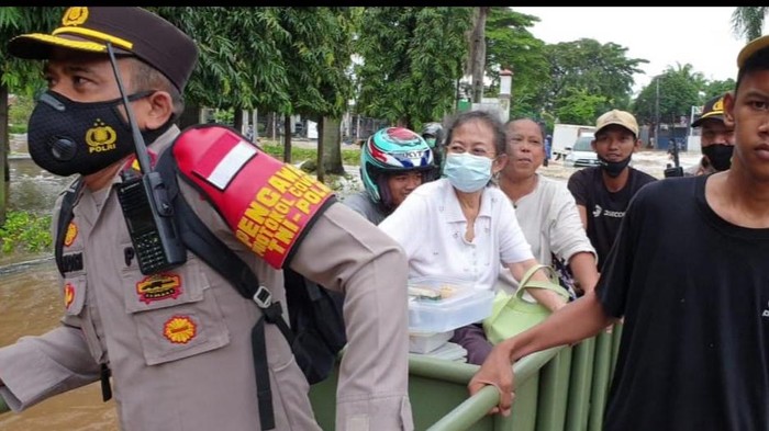 Kapolsek Kembangan menolong nenek-nenek yang terjebak banjir (Dok Polsek Kembangan)