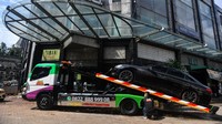 Petugas mengangkut mobil yang sempat terendam banjir di kawasan Kemang, Jakarta Selatan, Minggu (21/2/2021).
