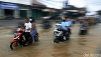 Pemotor nekat menerobos genangan.