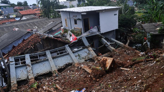 Warga mengambil air di bawah bangunan yang terkena longsor di kawasan Bangka, Jakarta Selatan, Minggu (21/2/2021). Sebanyak lima rumah tertimpa tanah longsor akibat curah hujan yang tinggi pada Sabtu, 20 Februari dini hari namun demikian tidak ada korban jiwa dalam peristiwa itu. ANTARA FOTO/Sigid Kurniawan/wsj.