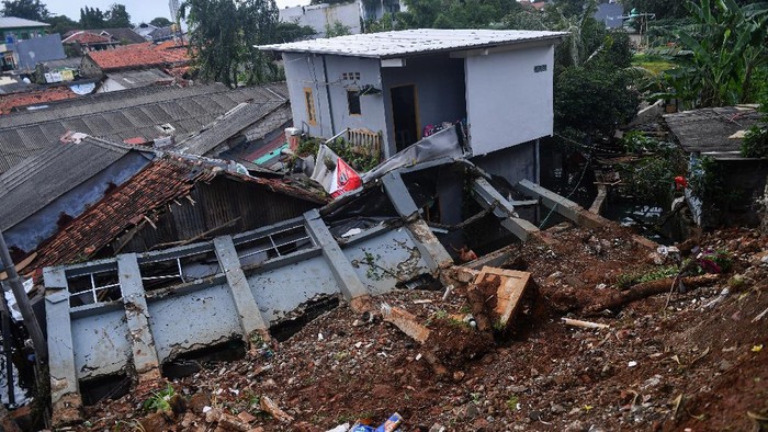 TANAH LONGSOR DI JAKARTA SELATAN Warga mengambil air di bawah bangunan yang terkena longsor di kawasan Bangka, Jakarta Selatan, Minggu (21/2/2021). Sebanyak lima rumah tertimpa tanah longsor akibat curah hujan yang tinggi pada Sabtu, 20 Februari dini hari namun demikian tidak ada korban jiwa dalam peristiwa itu. ANTARA FOTO/Sigid Kurniawan/wsj.
