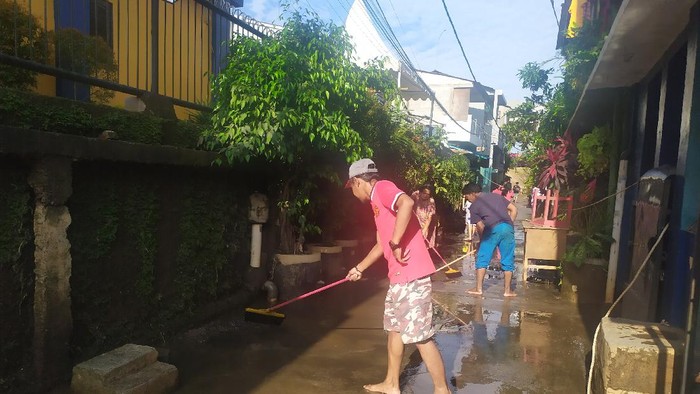Warga Cipinang Melayu Bersih-bersih Lumpur Sisa Banjir