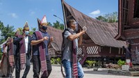 Wisatawan menari tarian tor tor di depan patung Sigale-gale di Desa Wisata Tomok, Simanindo, Samosir, Sumatera Utara, Minggu (21/2/2021).