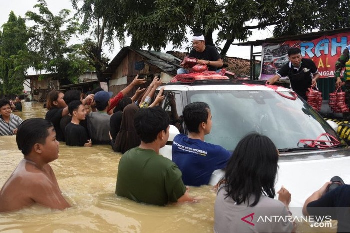 Dedi Mulyadi Nekat Bawa Mobil Mewah Terobos Banjir. Ini ia lakukan untuk membagi-bagikan bantuan ke warga yang terdampak banjir.