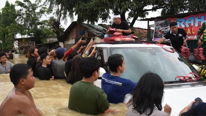 Dedi Mulyadi Nekat Bawa Mobil Mewah Terobos Banjir. Ini ia lakukan untuk membagi-bagikan bantuan ke warga yang terdampak banjir.