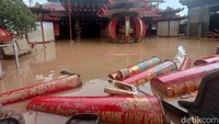 Tampak puluhan lilin berserakan akibat terjangan banjir luapan Sungai Citarum, dan Cibeet.  Lilin kecil mengambang sebagian, dan yang besar tergelatak di gerbang pintu masuk kelentengnya.