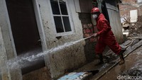 Petugas Pemadam Kebakaran membersihkan sisa lumpur pasca banjir di kawasan Tebet, Jakarta, Senin (22/2/2021).