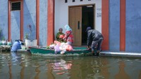 Pasutri warga Panjang Wetan, Pekalongan Utara, ini tetap beraktivitas dengan berjualan sayur keliling naik perahu di tengah banjir. ANTARA FOTO/Harviyan Perdana Putra