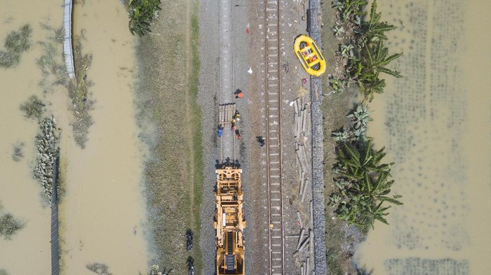 Petugas memperbaiki rel kereta api yang rusak akibat banjir di Kedungwaringin, Kabupaten Bekasi, Jawa Barat, Senin (22/2/2021). PT KAI membatalkan sementara perjalanan Kereta API (KA) jarak jauh dan KA lokal keberangkatan Daop 1 Jakarta karena adanya kerusakan pondasi batu pada rel karena tergerus air luapan banjir di Lemah Abang Km 55+100 sampai dengan Km 53+600. ANTARA FOTO/ Fakhri Hermansyah/aww.