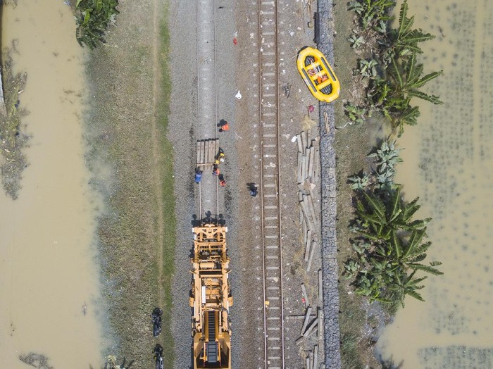 Petugas memperbaiki rel kereta api yang rusak akibat banjir di Kedungwaringin, Kabupaten Bekasi, Jawa Barat, Senin (22/2/2021). PT KAI membatalkan sementara perjalanan Kereta API (KA) jarak jauh dan KA lokal keberangkatan Daop 1 Jakarta karena adanya kerusakan pondasi batu pada rel karena tergerus air luapan banjir di Lemah Abang Km 55+100 sampai dengan Km 53+600. ANTARA FOTO/ Fakhri Hermansyah/aww.
