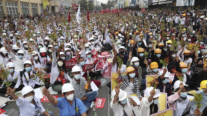 Protesters hold images of ousted leader Aung San Suu Kyi during an anti-coup protest in Mandalay, Myanmar, Sunday, Feb. 21, 2021. Police in Myanmar shot dead a few anti-coup protesters and injured several others on Saturday, as security forces increased pressure on popular revolt against the military takeover. (AP Photo)