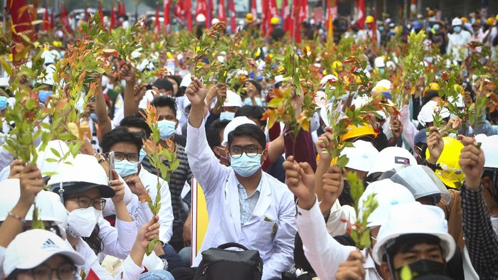 Puluhan Ribu Warga Myanmar Terus Demo Tolak Kudeta Militer Protesters hold images of ousted leader Aung San Suu Kyi during an anti-coup protest in Mandalay, Myanmar, Sunday, Feb. 21, 2021. Police in Myanmar shot dead a few anti-coup protesters and injured several others on Saturday, as security forces increased pressure on popular revolt against the military takeover. (AP Photo)
