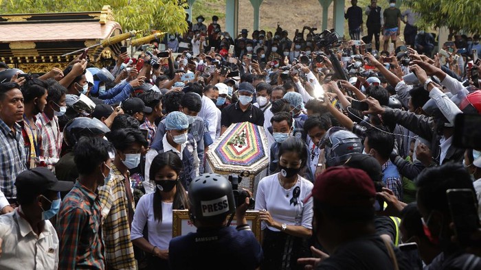 The casket containing the body of Mya Thwet Thwet Khine being carried through the crowds towards the cemetery in Naypyitaw Myanmar, Sunday, Feb. 21, 2021. Mya Thwet Thwet Khine was the first confirmed death among the many thousands who have taken to the streets to protest the Feb. 1 coup that toppled the elected government of Aung San Suu Kyi. The woman was shot on Feb. 9, two days before her 20th birthday, at a protest in the capital Nayptitaw, and died Friday. (AP Photo)