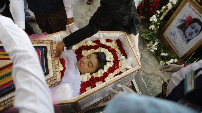 Ribuan Warga Myanmar Hadiri Pemakaman Demonstran yang Tewas Ditembak The casket containing the body of Mya Thwet Thwet Khine being carried through the crowds towards the cemetery in Naypyitaw Myanmar, Sunday, Feb. 21, 2021. Mya Thwet Thwet Khine was the first confirmed death among the many thousands who have taken to the streets to protest the Feb. 1 coup that toppled the elected government of Aung San Suu Kyi. The woman was shot on Feb. 9, two days before her 20th birthday, at a protest in the capital Nayptitaw, and died Friday. (AP Photo)