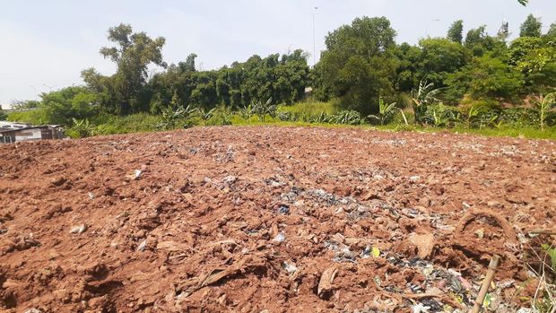 Sampah seluas lapangan sepak bola di Kampung Caman Kota Bekasi, ditutup dengan tanah merah.