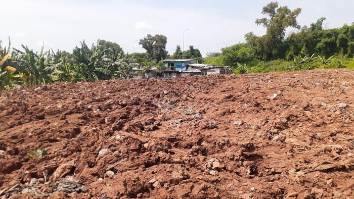Sampah seluas lapangan sepak bola di Kampung Caman Kota Bekasi, ditutup dengan tanah merah.