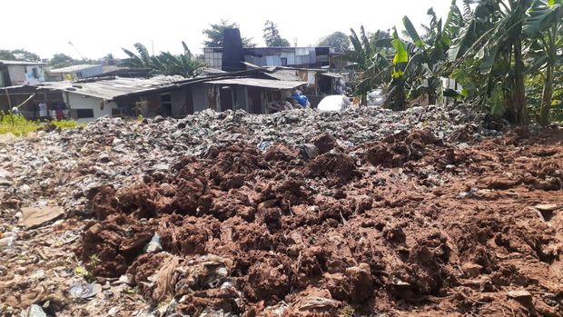 Sampah seluas lapangan sepak bola di Kampung Caman Kota Bekasi, ditutup dengan tanah merah.