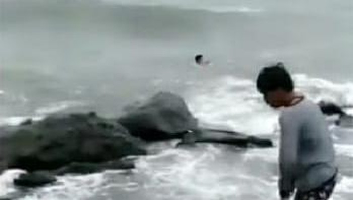 Tangkapan layar video viral 2 pria di Makassar terjun ke gelombang tinggi laut demi selamatkan bocah tenggelam (dok. Istimewa).